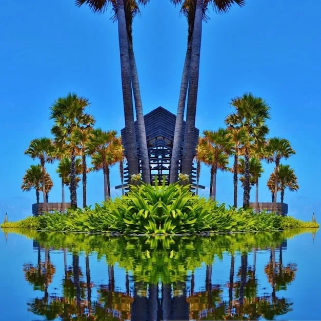 A modern condominium building overlooking a blue ocean in a tropical setting, with lush palm trees.