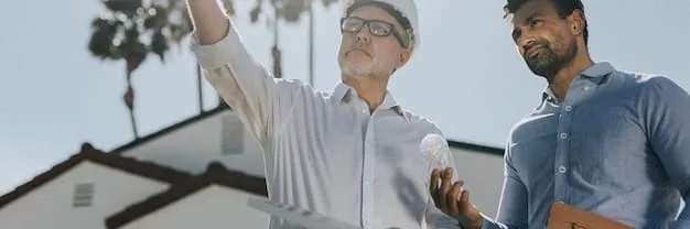 Two construction executives, one American and one Mexican, shaking hands firmly in front of a blueprint, symbolizing a successful joint venture in the construction industry.
