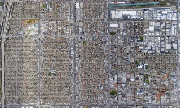 An aerial view of a bustling cross-border industrial park, with factories on both sides of the US-Mexico border, symbolizing the intertwined economies and a skilled workforce moving between roles.