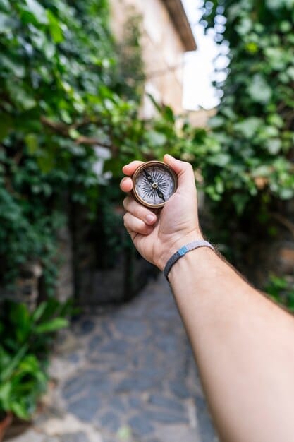 A close-up shot of a hand holding a piece of raw silver ore, with a blurred background showing Mexican folk art, symbolizing the intersection of mineral wealth and cultural heritage for US investors.