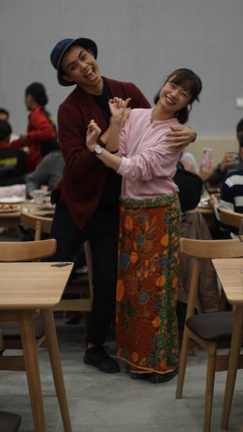 A group of international students participating in a cultural integration workshop, learning traditional Mexican dances with a local instructor, showcasing elements of community and joyful learning.