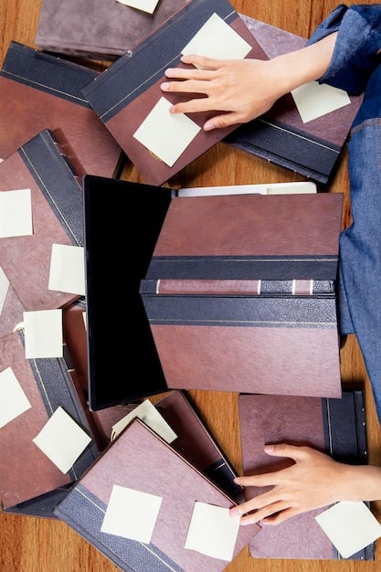 An overhead shot of a person's hands meticulously organizing documents in a file folder, with various financial papers and a pen on a wooden table, symbolizing careful record-keeping and organization for tax purposes.
