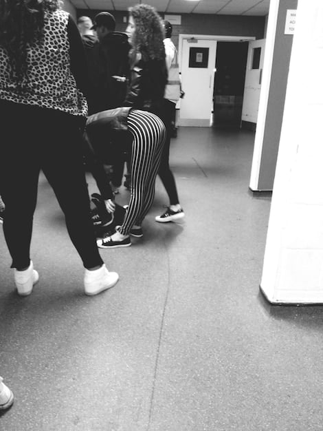 A visual representation of a diverse group of people, appearing to be in a waiting room or community center, with subtle visual cues of different demographics (e.g., a family with children, an older person), all looking towards a blurry, positive light source. The image conveys hope and community support.