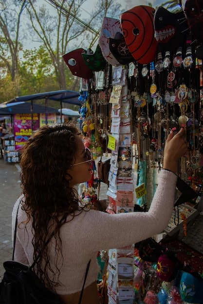 A bustling street market in Oaxaca, Mexico, with American tourists interacting with local vendors selling colorful textiles, pottery, and traditional food, illustrating cultural exchange and economic support.