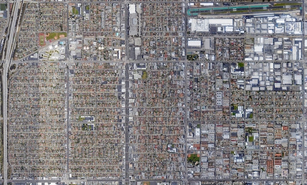 An aerial view of a bustling cross-border industrial park, with factories on both sides of the US-Mexico border, symbolizing the intertwined economies and a skilled workforce moving between roles.